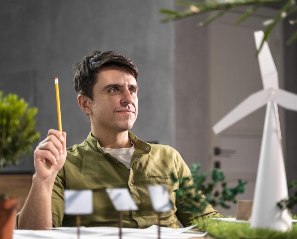 front view man thinking about eco friendly wind power project with wind turbines scaled